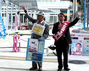 JR明石駅前で永井俊作明石市議(左)と並んで政策を訴えるきくち憲之